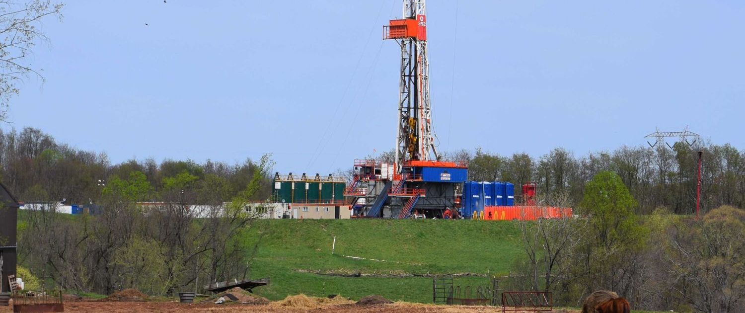 Drilling rig on a CNX (Consol Energy) fracking pad beyond a cattle pasture in Noble County, Ohio.