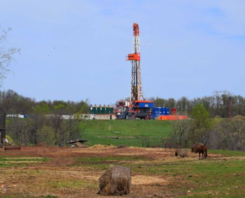 Drilling rig on a CNX (Consol Energy) fracking pad beyond a cattle pasture in Noble County, Ohio.
