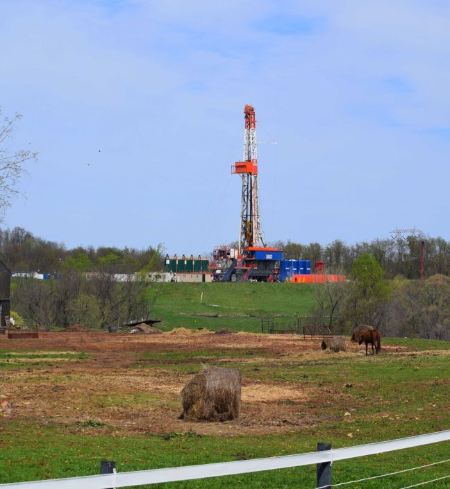 TAuch_Infrastructure-FrackPad_DrillRig-ConsolEnergy_CNX-NobleCounty_OH_April2017 Drilling rig on a CNX (Consol Energy) fracking pad beyond a cattle pasture in Noble County, Ohio.