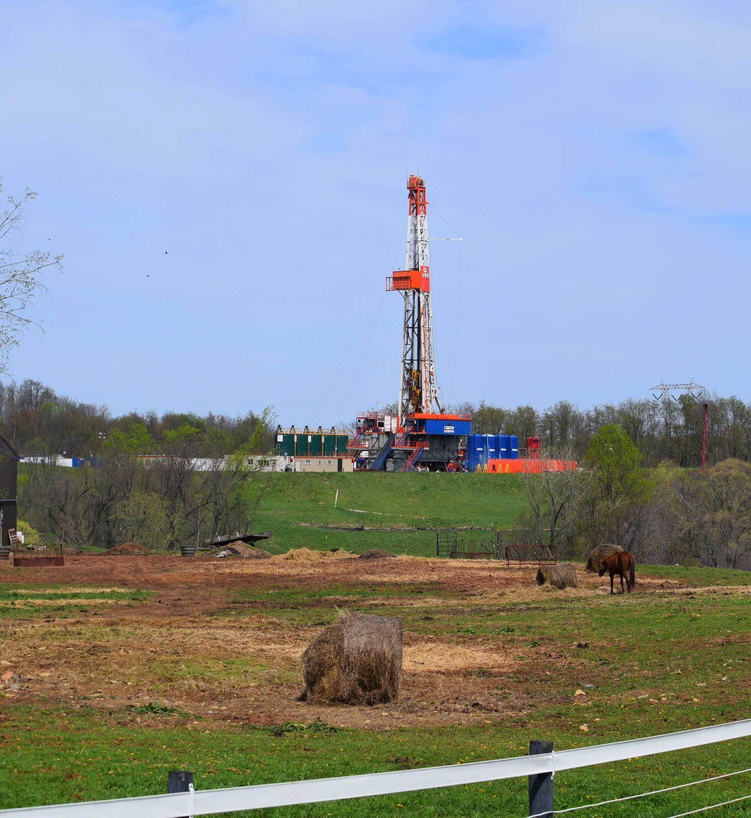 Drilling rig on a CNX (Consol Energy) fracking pad beyond a cattle pasture in Noble County, Ohio.