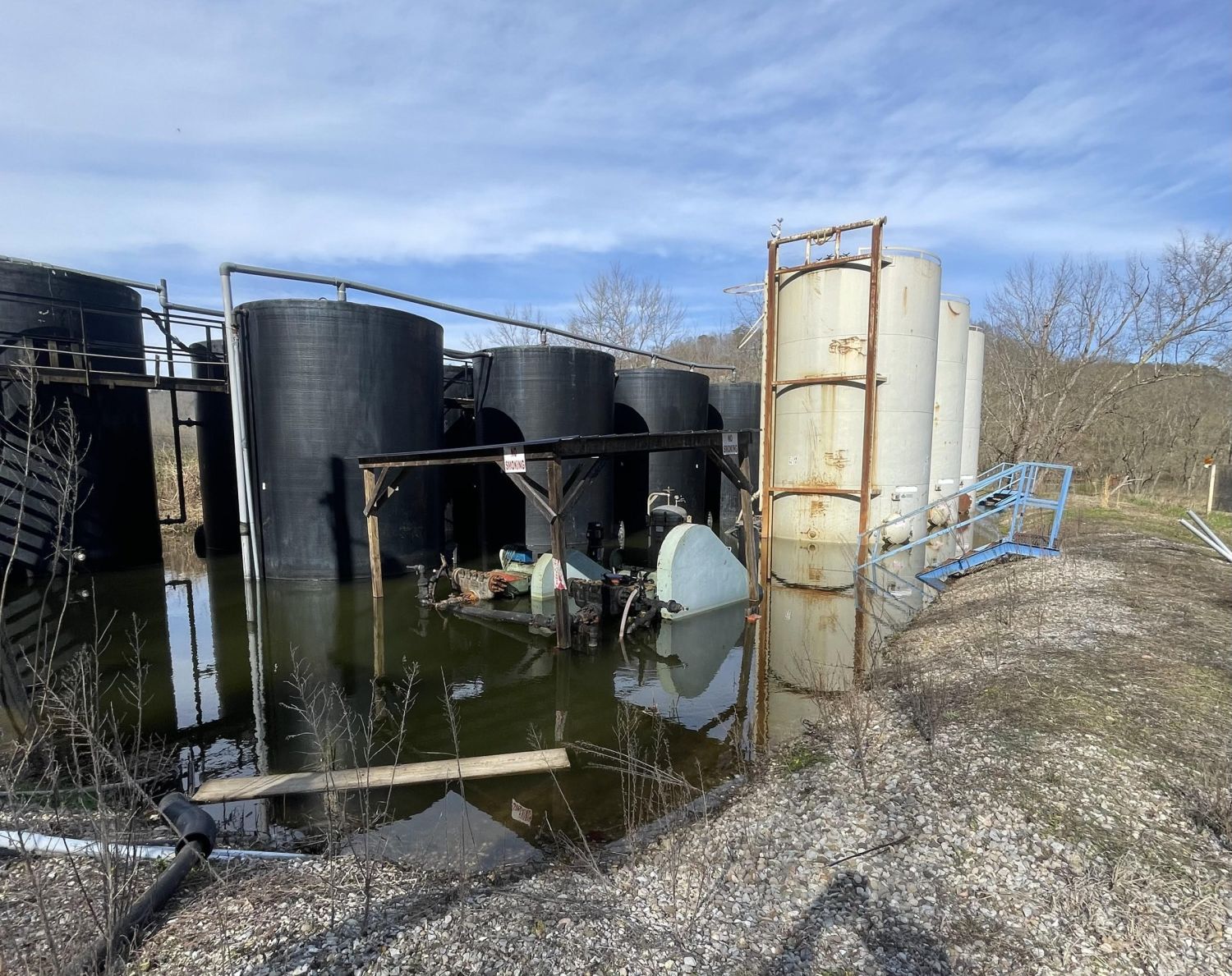 Storage tanks at the Frost well, a Class II injection well site in Athens County, Ohio, standing in pooled water.